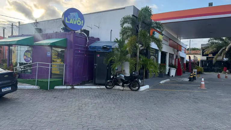 Lavô Busca Vida vista de longe, dentro do Posto Atlântico e ao lado da loja de conveniência, com estacionamento em frente